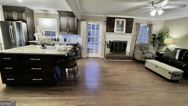 kitchen with ornamental molding, open floor plan, dark wood-type flooring, and freestanding refrigerator