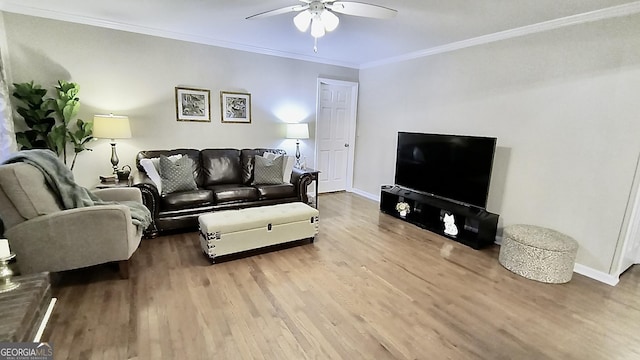 living room featuring baseboards, crown molding, a ceiling fan, and wood finished floors