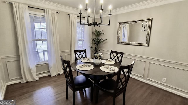 dining area with dark wood-style floors, ornamental molding, a decorative wall, and a notable chandelier