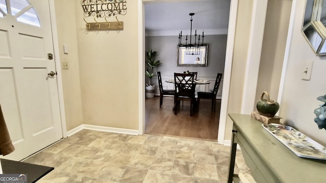 entrance foyer featuring baseboards and a chandelier