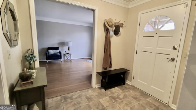 foyer featuring baseboards and ornamental molding