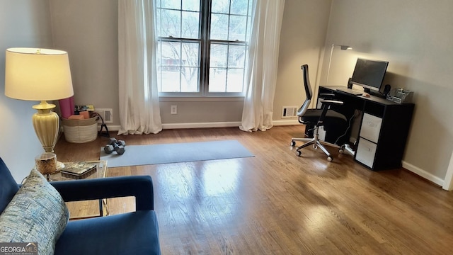 home office with visible vents, baseboards, and wood finished floors