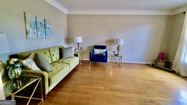 living room with baseboards, crown molding, and wood finished floors