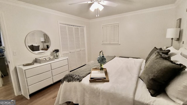 bedroom featuring ornamental molding, a ceiling fan, a closet, and wood finished floors