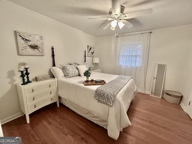 bedroom featuring dark wood-style floors, baseboards, and a ceiling fan