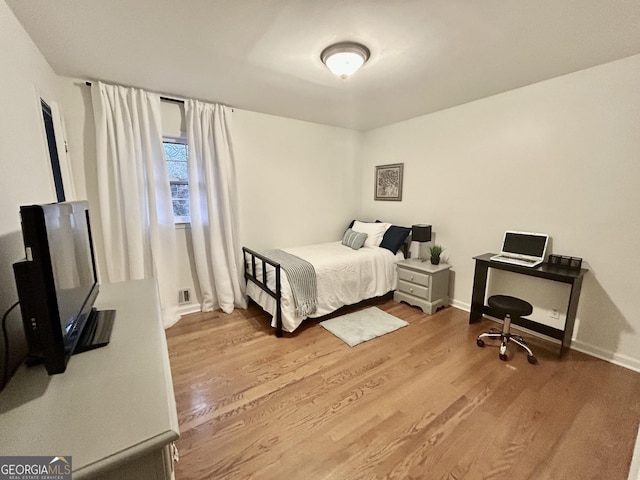 bedroom with baseboards and wood finished floors