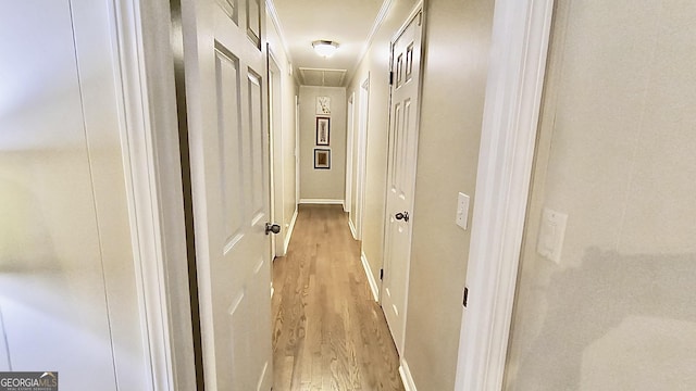 hall with attic access and light wood-type flooring