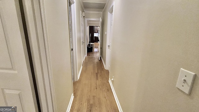 hall with light wood-style floors and baseboards