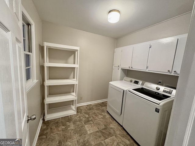 laundry room featuring cabinet space, baseboards, and washer and clothes dryer