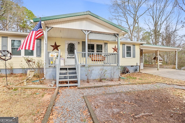 view of front of property with a carport, driveway, a porch, and crawl space