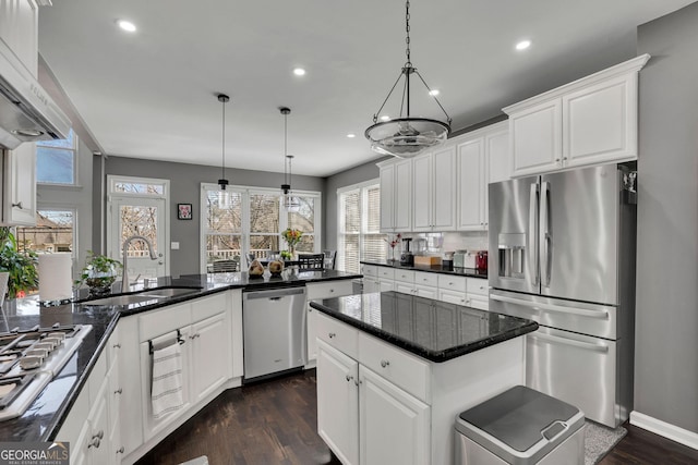 kitchen with appliances with stainless steel finishes, white cabinets, dark wood-type flooring, and a sink