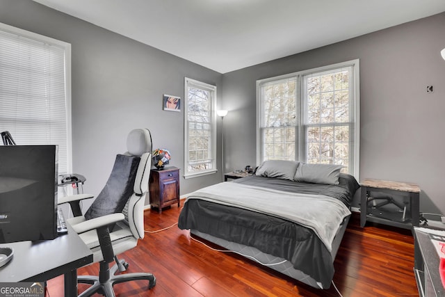 bedroom with wood-type flooring and baseboards