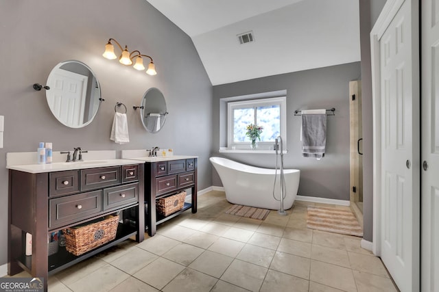 bathroom featuring lofted ceiling, tile patterned flooring, vanity, visible vents, and a soaking tub