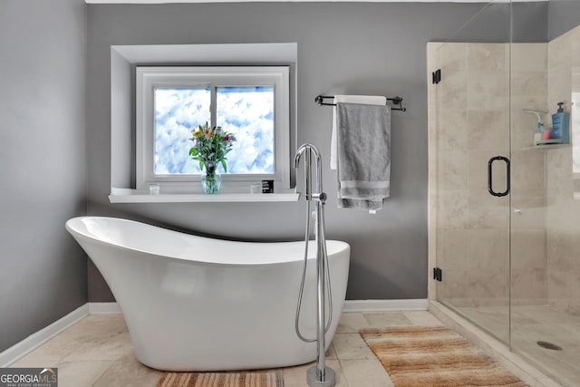 full bath with a stall shower, a soaking tub, and baseboards