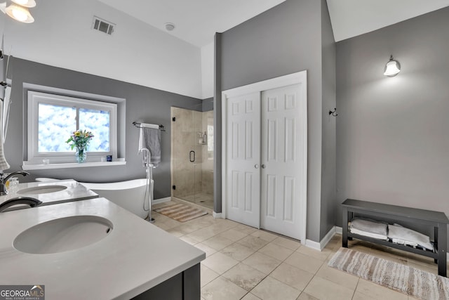 bathroom featuring double vanity, a stall shower, a sink, and visible vents