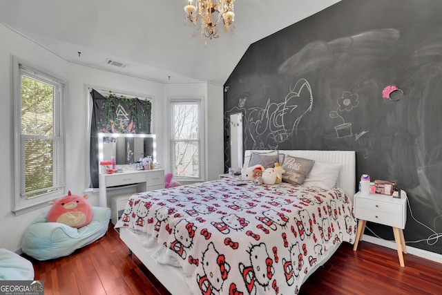 bedroom featuring lofted ceiling, multiple windows, and wood finished floors