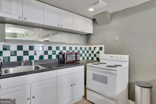 kitchen with electric stove, a sink, white cabinets, and decorative backsplash