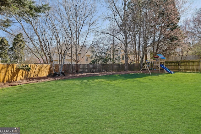 view of yard featuring a playground and a fenced backyard