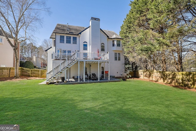 back of property with a fenced backyard, stairway, and a yard