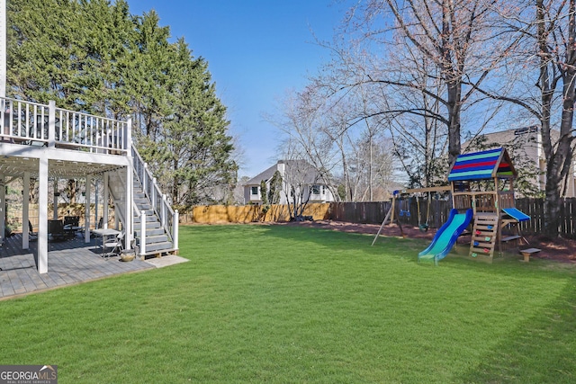 view of yard featuring stairs, a patio, a playground, and a fenced backyard