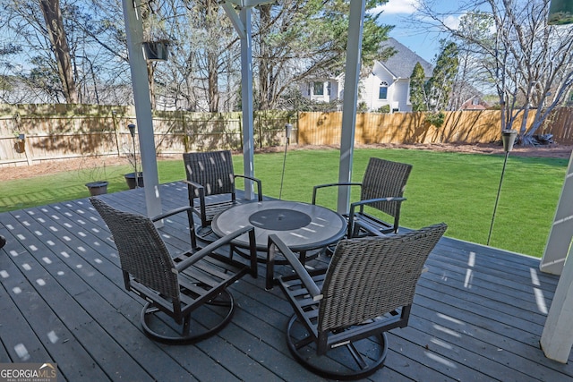 wooden terrace featuring outdoor dining area, a fenced backyard, and a yard