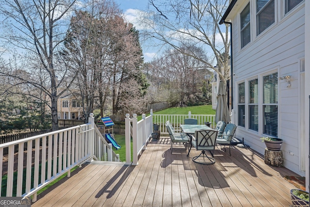 wooden terrace with outdoor dining area and fence