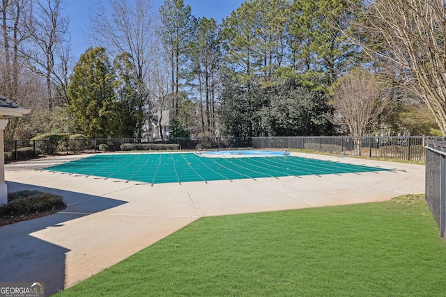 view of swimming pool featuring a lawn, fence, and a fenced in pool