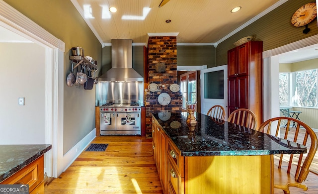 kitchen featuring visible vents, wall chimney exhaust hood, ornamental molding, light wood-type flooring, and double oven range