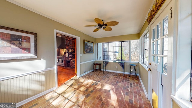 unfurnished sunroom featuring a ceiling fan