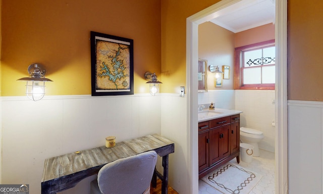 bathroom featuring a wainscoted wall, vanity, toilet, and tile patterned floors