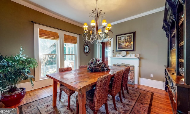 dining room with baseboards, ornamental molding, a chandelier, and wood finished floors