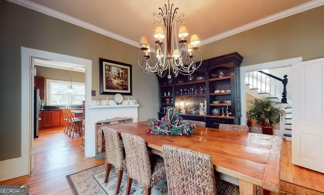 dining space featuring stairs, ornamental molding, and light wood-style floors