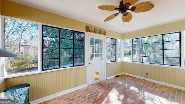 unfurnished sunroom featuring ceiling fan