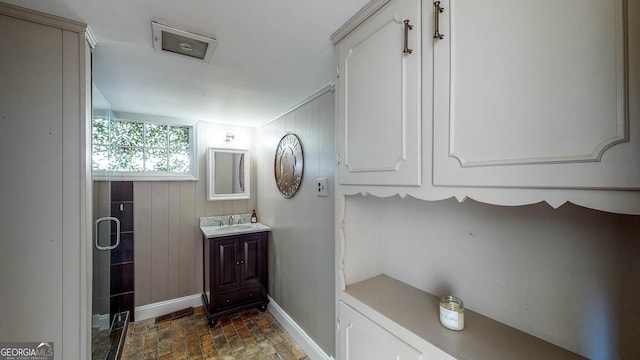 full bath with wood walls, a stall shower, vanity, and baseboards