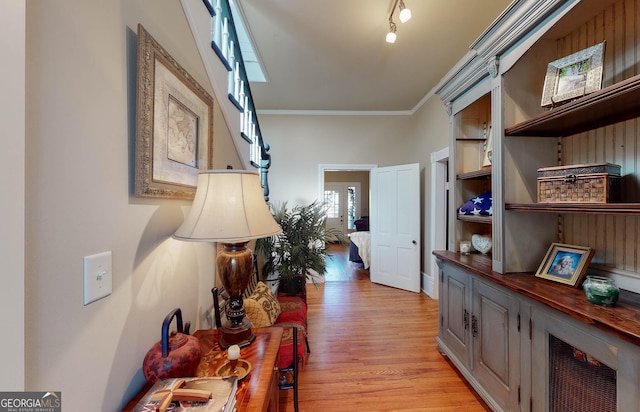 corridor featuring ornamental molding and light wood finished floors