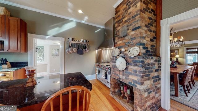 interior space featuring ornamental molding, a notable chandelier, light wood-style flooring, and baseboards