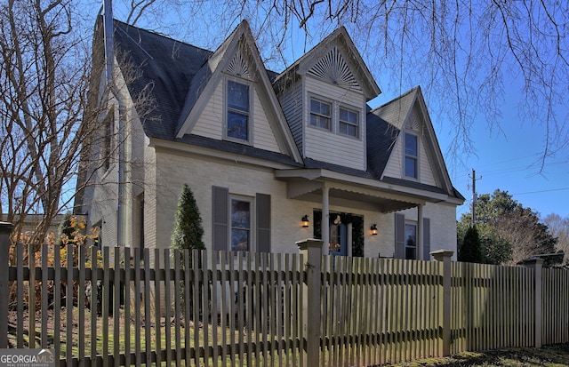 view of front facade with a fenced front yard and brick siding