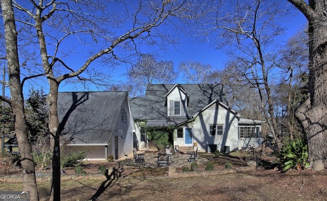 view of front of home with a garage and roof with shingles