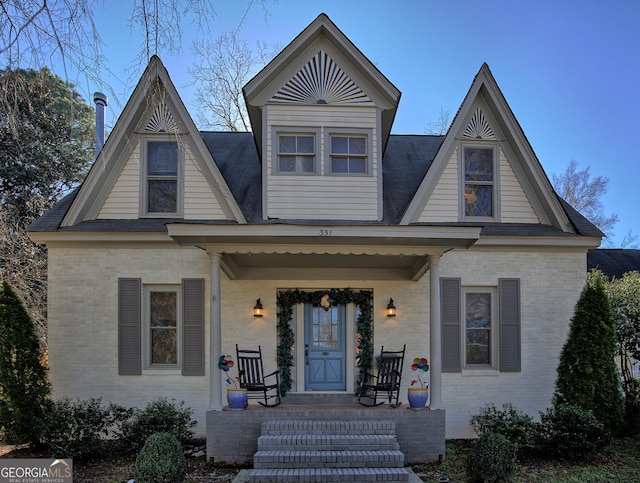 view of front facade with covered porch and brick siding