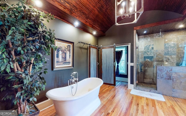 bathroom with a stall shower, lofted ceiling, a soaking tub, wood ceiling, and wood finished floors