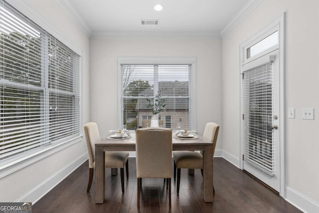 dining space featuring visible vents, baseboards, dark wood-type flooring, and crown molding