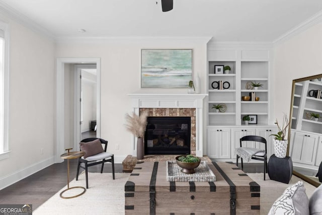 living room featuring wood finished floors, baseboards, a glass covered fireplace, and ornamental molding