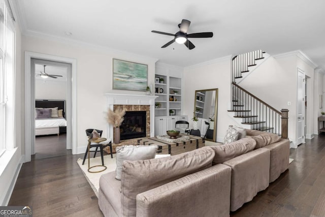 living room featuring crown molding, stairway, built in features, and dark wood-type flooring