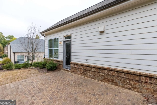 view of exterior entry with a patio