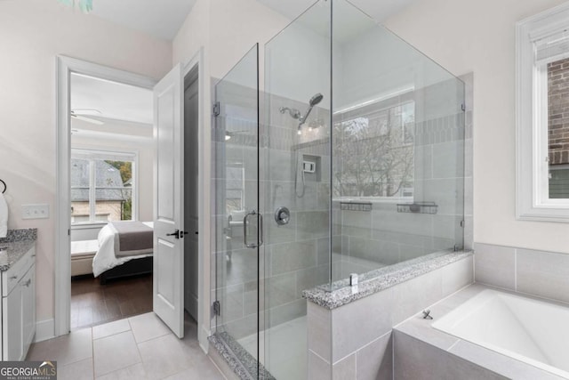 ensuite bathroom featuring vanity, ensuite bath, a shower stall, a garden tub, and tile patterned floors