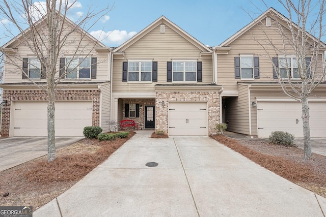 multi unit property featuring concrete driveway, brick siding, and an attached garage