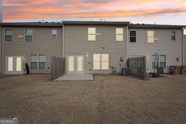 rear view of house featuring french doors, a lawn, a patio, and central air condition unit