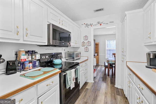 kitchen with light countertops, range with electric cooktop, and stainless steel microwave