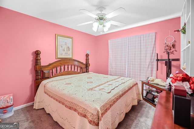 carpeted bedroom with ceiling fan, baseboards, and a textured ceiling