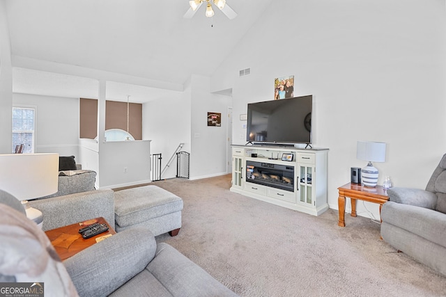 living room with high vaulted ceiling, a ceiling fan, visible vents, baseboards, and carpet